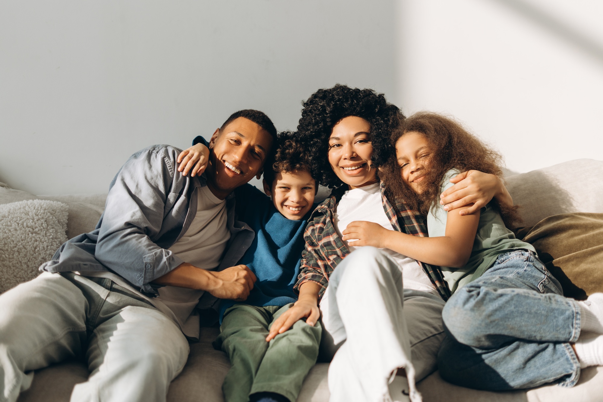 Happy African American family embracing on sofa at home